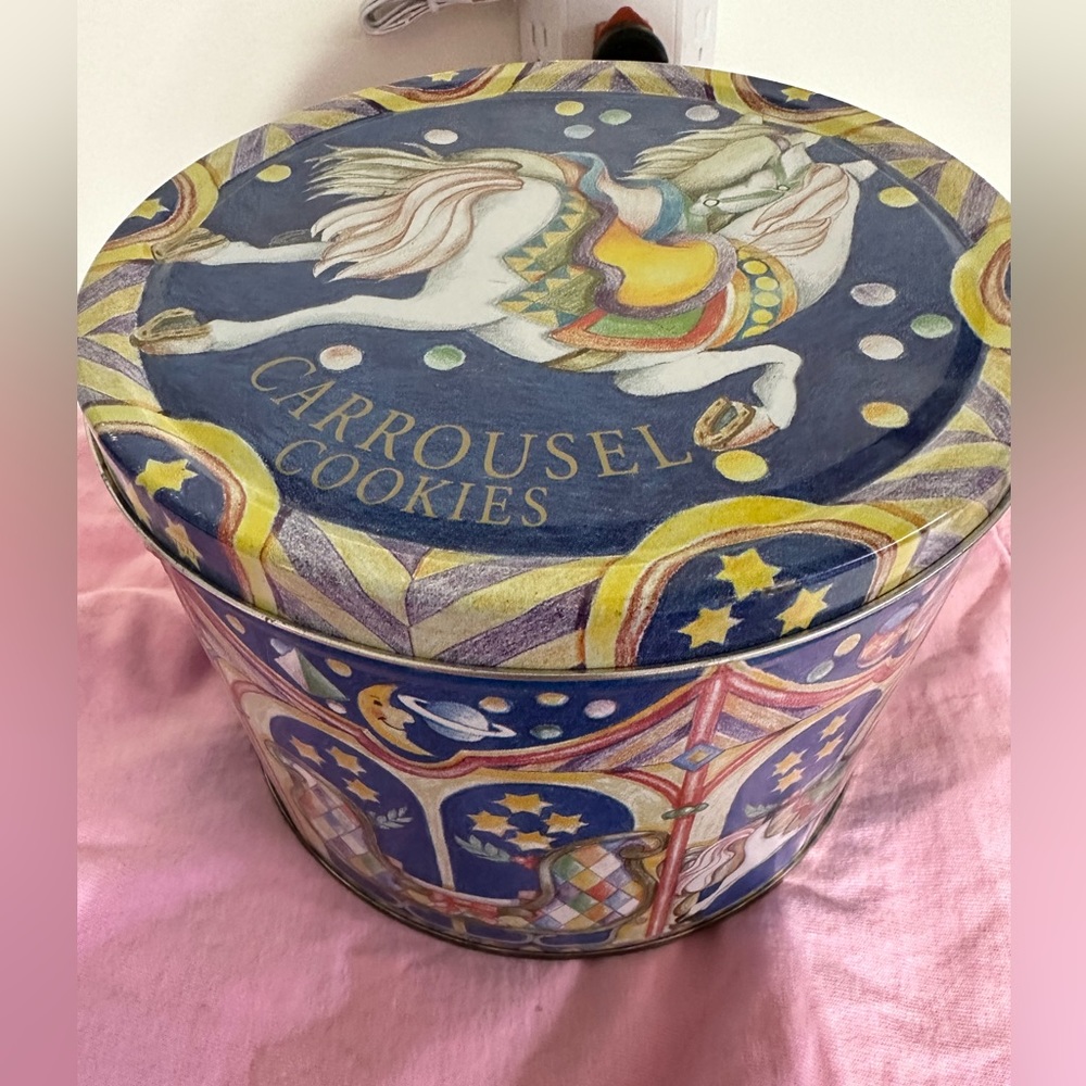 Old metal tin Carrousel Cookies on top of it with Carrousel Horses around side